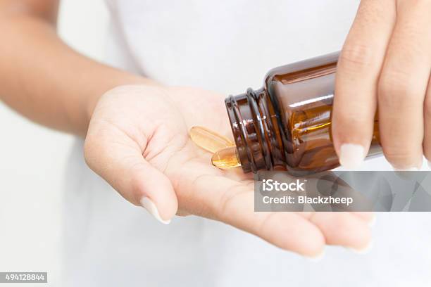 Foto de Detalhe De Mão Segurando Óleo De Peixe De Vitamina Saudáveis e mais fotos de stock de Suplemento nutricional