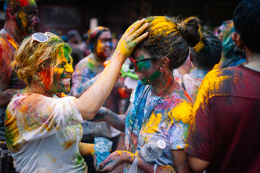 Kuala Lumpur, Malaysia - March 31, 2013. A western woman covered in colored powder enjoy the Indian Holi Festival. Participants throw each other colored powder as they celebrate the Hindu festival of Holi, also known as Festival of Colors.