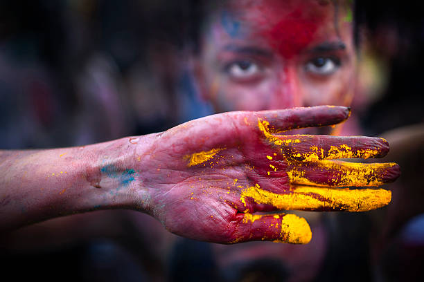 Kuala Lumpur, Malaysia - March 31, 2013. A western woman with color powder smeared on her hand and face during celebrating Holi Festival. Holi, the Hindu festival of colors will be celebrated across the country every year.
