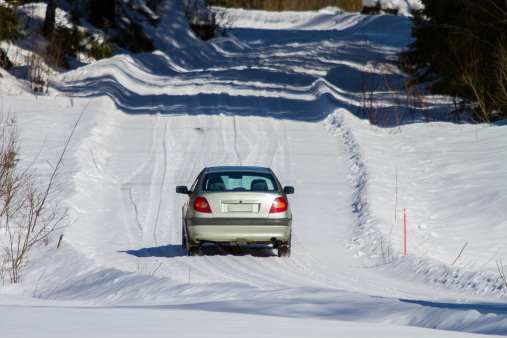 Driving a car on  the small winter road