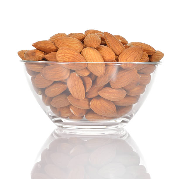 istock Almonds in a glass bowl on white background. 494149411
