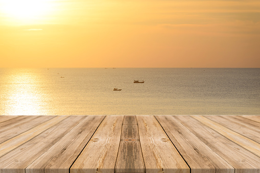 Vintage wooden board empty table in front of sunset background. Perspective wood floor over sea and sky - can be used for display or montage your products. beach & summer concepts.