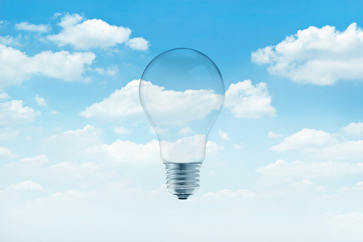 Bulb light on blue sky with white clouds background
