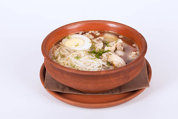 istock chicken soup with rice, egg and noodles in brown clay 494155266