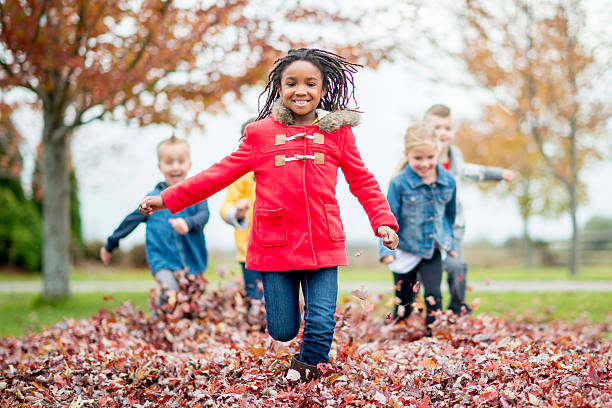 menina a correr através de uma pilha de folha - family african ethnicity black african descent imagens e fotografias de stock