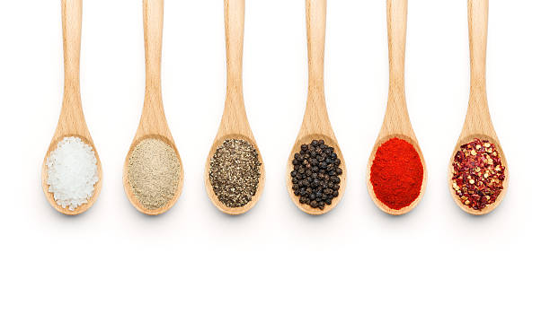 Wooden Spoon filled with various spices Wooden Spoon filled with various spices on white background salt seasoning stock pictures, royalty-free photos & images