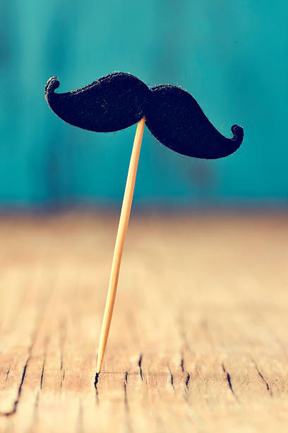 istock felt mustache in stick on a wooden surface 494159256