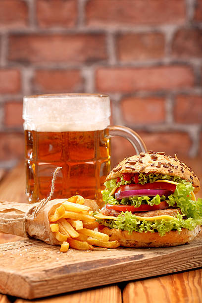istock Grilled hamburger with fries and beer on brick wall background 494162678