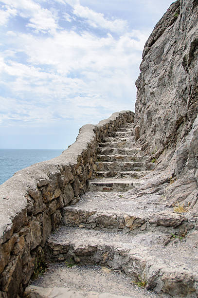 istock Stone ladder cut from the rock over sea 494164342