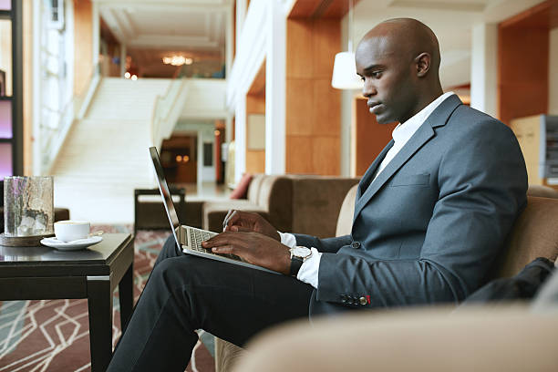istock Busy young businessman working on laptop in lobby 494165472