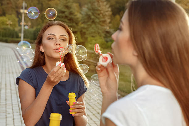 istock Two attractive girls blowing bubbles 494165706