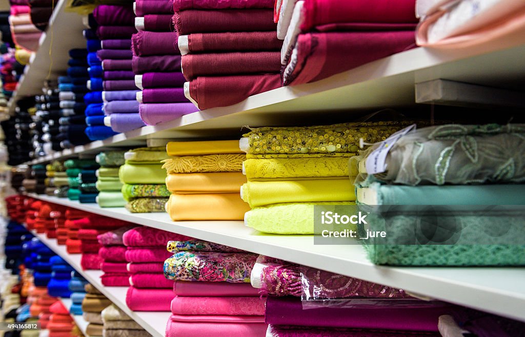 Rolls of fabric and textiles in a factory shop store Rolls of fabric and textiles in a factory shop or  store or bazar. Multi different colors and patterns on the market. Industrial fabrics. Textile Stock Photo
