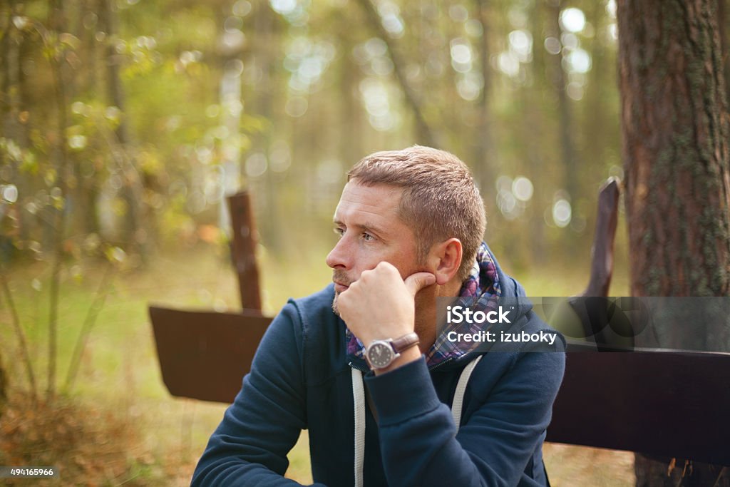 man thinking moody portrait, sitting at autumn park man thinking moody portrait, sitting at autumn park, selective focus Depression - Sadness Stock Photo