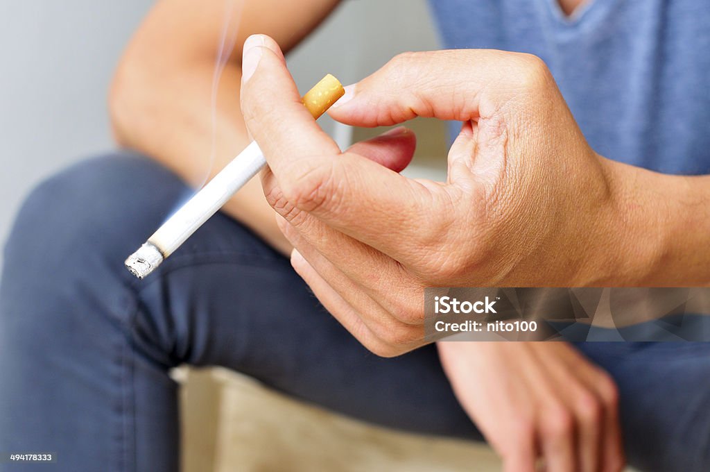 young man smoking a young man smoking a cigarette Addiction Stock Photo