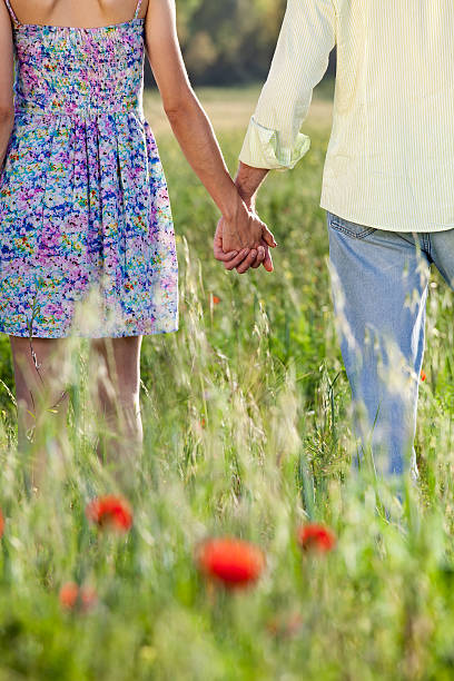 Romántico joven pareja sosteniendo las manos en una fecha. - foto de stock