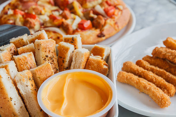 Pizza and chicken stick and bread stick on table.