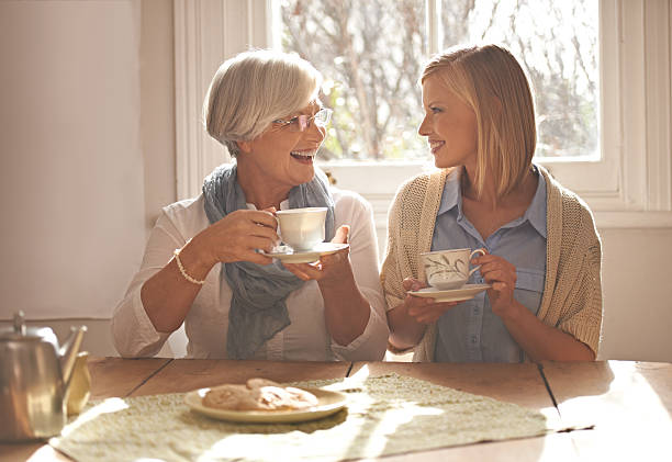 Daughter tea glass in hand while kissing his mother