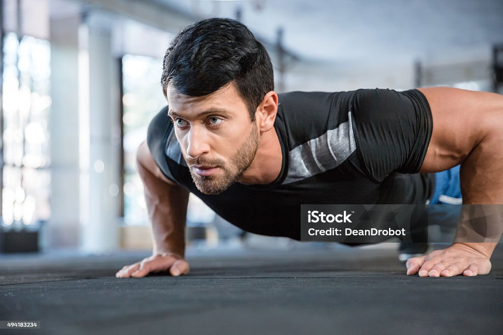 Man doing push ups in gym Portrait of a fitness man doing push ups in gym Push-ups Stock Photo