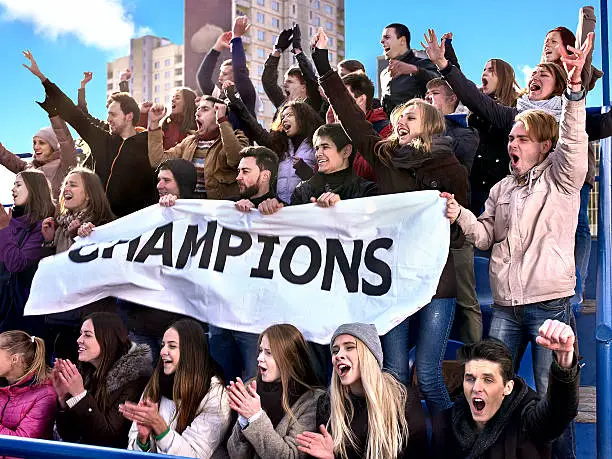 Photo of Sport fans holding champion banner on tribunes