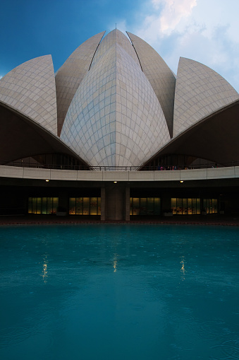 New Delhi. India- April 3, 2015: Group of believers visit the Lotus temple in New Delhi. The Lotus Temple, located in New Delhi, India, is a Bahá'í House of Worship completed in 1986. Notable for its flowerlike shape, it serves as the Mother Temple of the Indian subcontinent and has become a prominent attraction in the city.