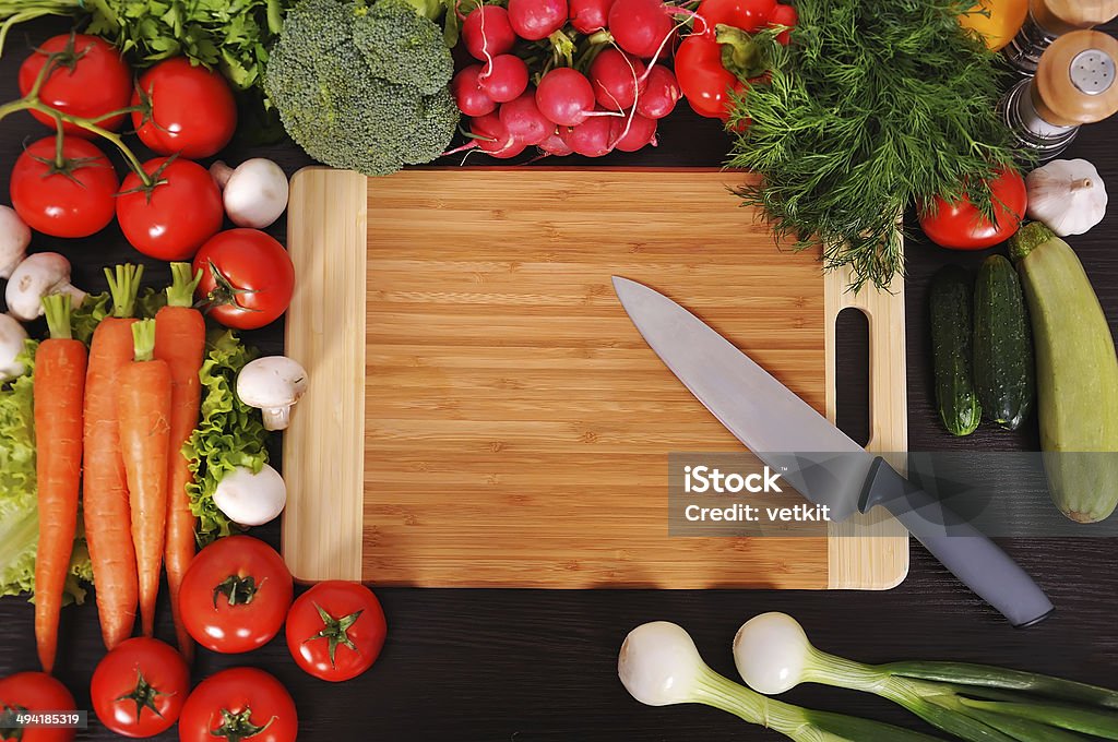 chopping board tomatoes, cucumber, garlic, knife, fresh herbs on chopping board Agriculture Stock Photo