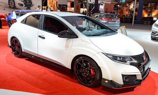 Amsterdam, The Netherlands - April 16, 2015: Honda Civic Type R hatchback car on display during the 2015 Amsterdam motor show. There are people looking around and other cars on display in the background.