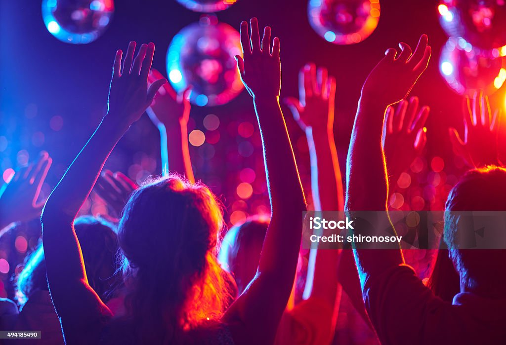 Dancing crowd Crowd of people with raised arms dancing in night club Nightclub Stock Photo