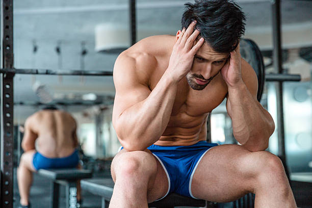 istock Pensive muscular man sitting on the bench 494185618