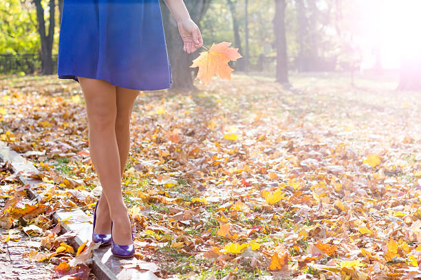 woman legs in high heels walking in the park
