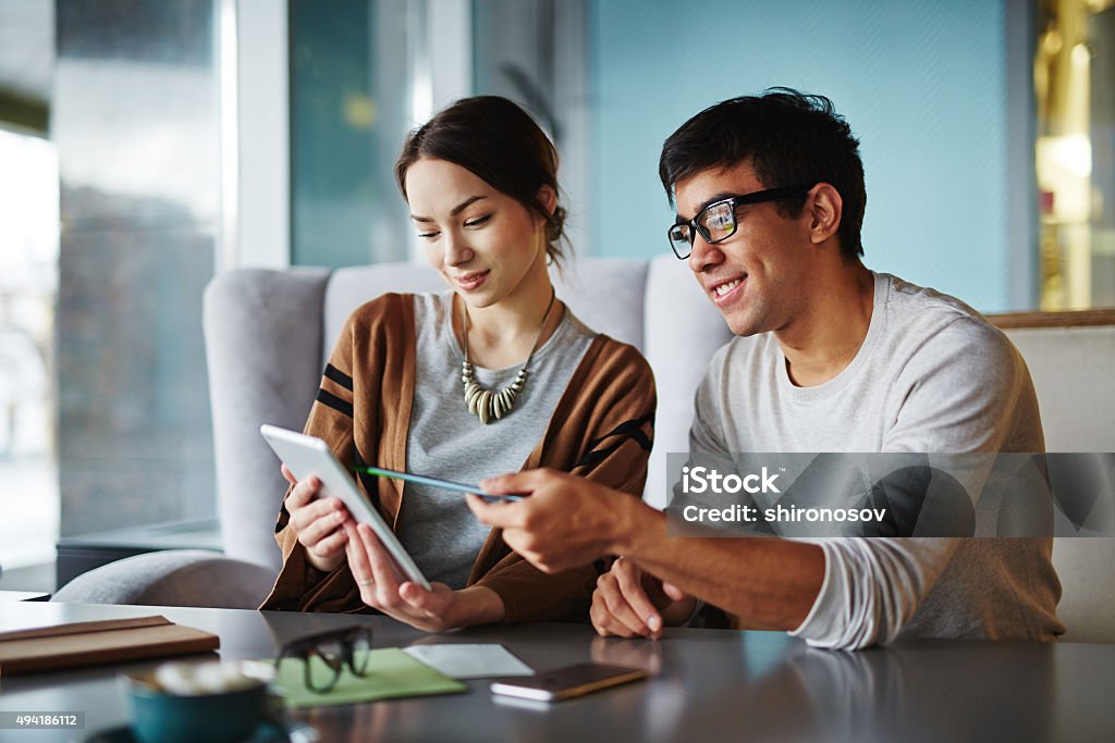 Explaining data Young man explaining data to his girlfriend Business Stock Photo