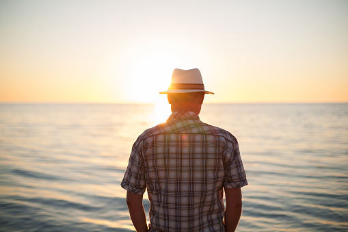 man standing backlight sunset lighting back view summer evening beach