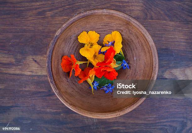 Colorful Edible Flowers In Clay Bowl On Wooden Background Stock Photo - Download Image Now