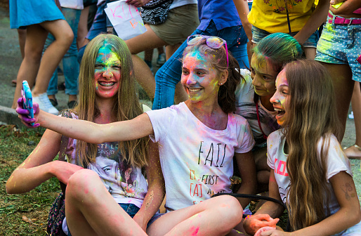  Lviv, Ukraine - August 30, 2015: Girls make self-portrait with mobile phone in a crowd of participants of the festival of color Lviv