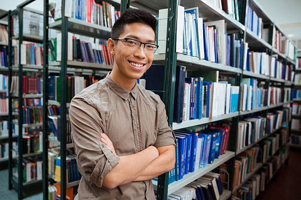istock Man standing with arms folded in university library 494195204