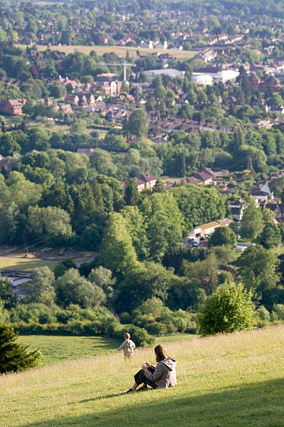 Mother and child playing in meadow England Box Hill, England - May 30, 2005: A mother watching her young child playing in the meadows  on the hill, overlooking Surrey. surrey england stock pictures, royalty-free photos & images