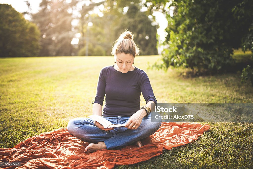 Woman Reading a Book in the Park Woman reading a book in the park. Adult Stock Photo