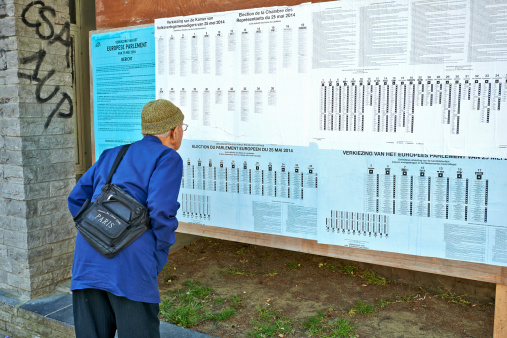 Brussels, Belgium - May 25,2014: European election  in Brussels. Old man looks at the election information panels.