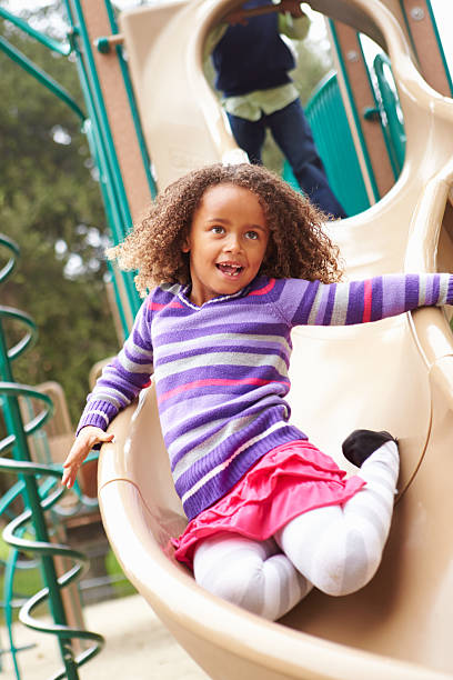 istock Young Girl Playing On Slide In Playground 494209195