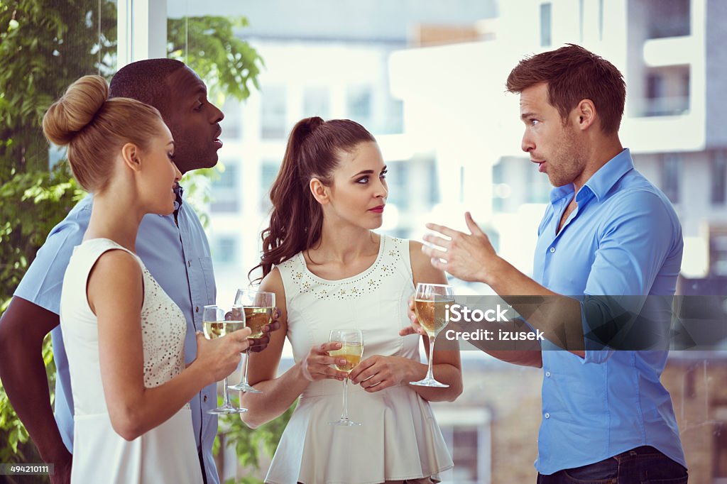 Friends meeting Group of friends talking over white wine with cityscape in the background.  20-24 Years Stock Photo
