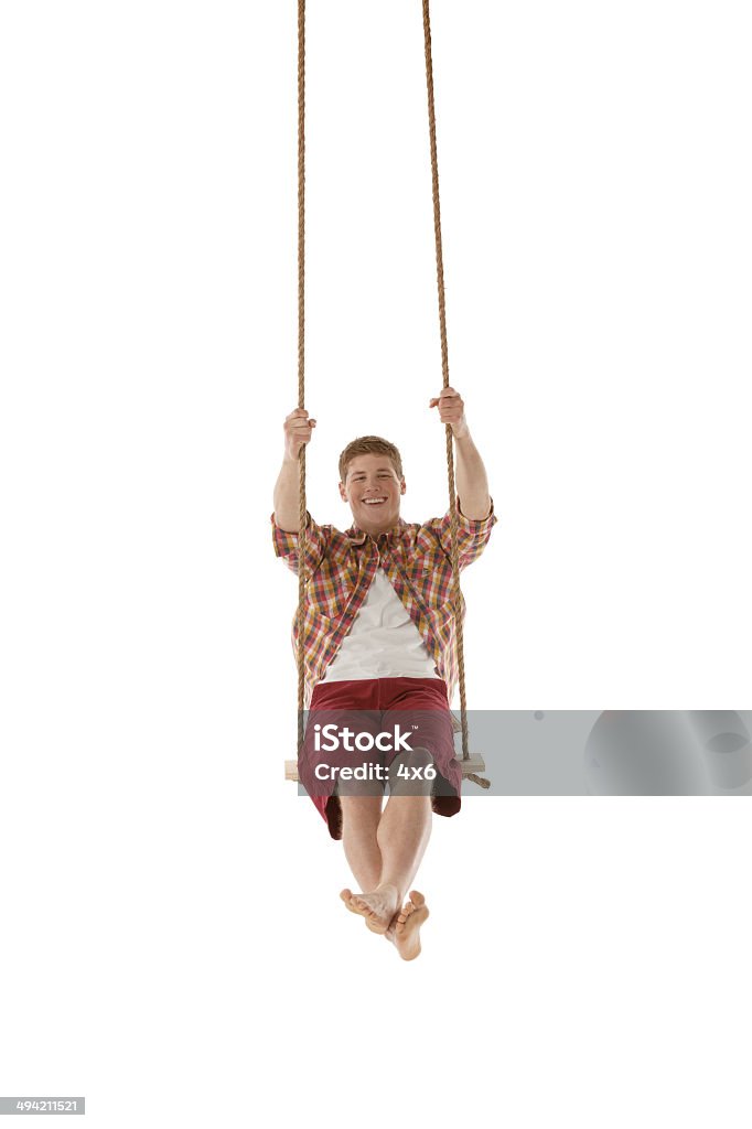 Happy young man swinging on a rope swing Happy young man swinging on a rope swinghttp://www.twodozendesign.info/i/1.png 20-29 Years Stock Photo