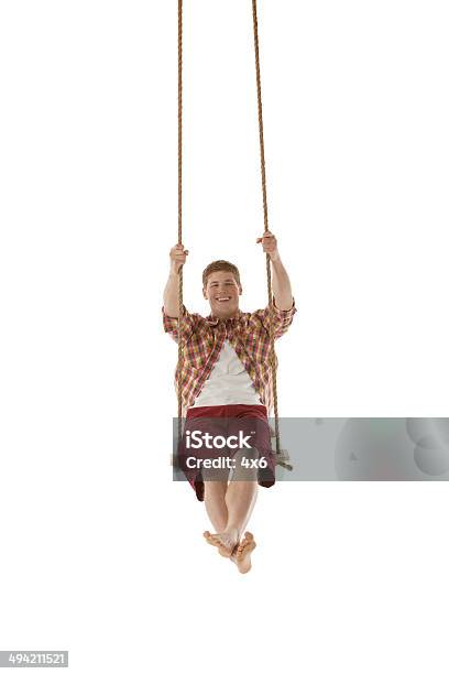 Happy Young Man Swinging On A Rope Swing Stock Photo - Download Image Now - 20-29 Years, Adult, Adults Only