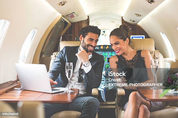 Business Couple Enjoying In Private Aeroplane Stock Photo - Download Image Now - Couple - Relationship, Private Airplane, Commercial Airplane