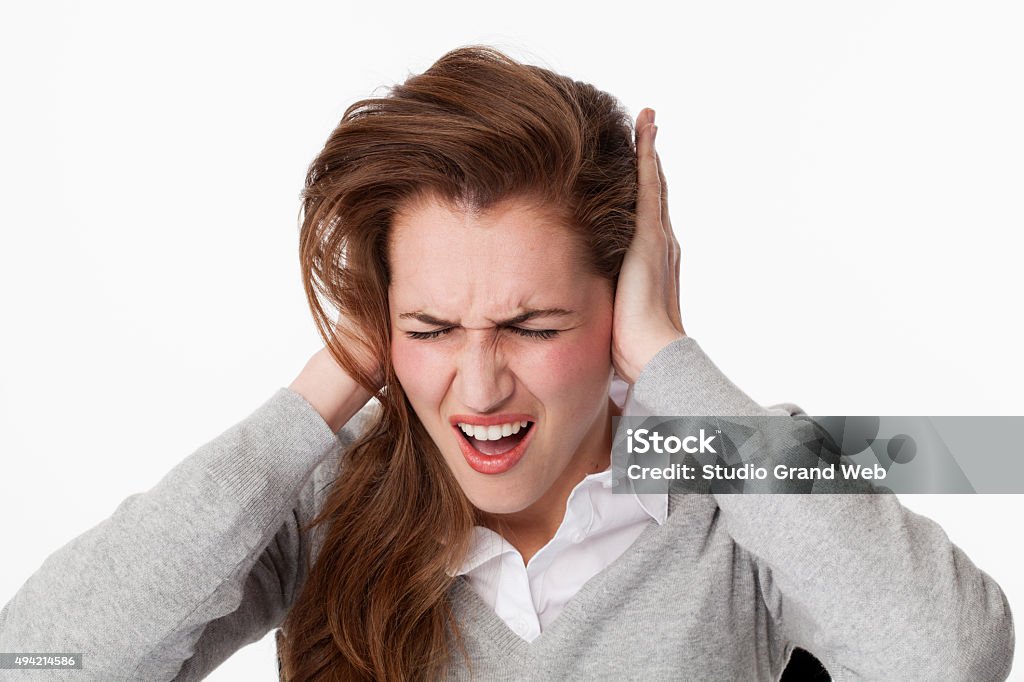 20s woman getting mad at tinnitus issue or loud music tinnitus concept - tensed young woman having painful migraine,covering closed ears,annoyed by loud noise not wanting to hear their side of story 20-29 Years Stock Photo