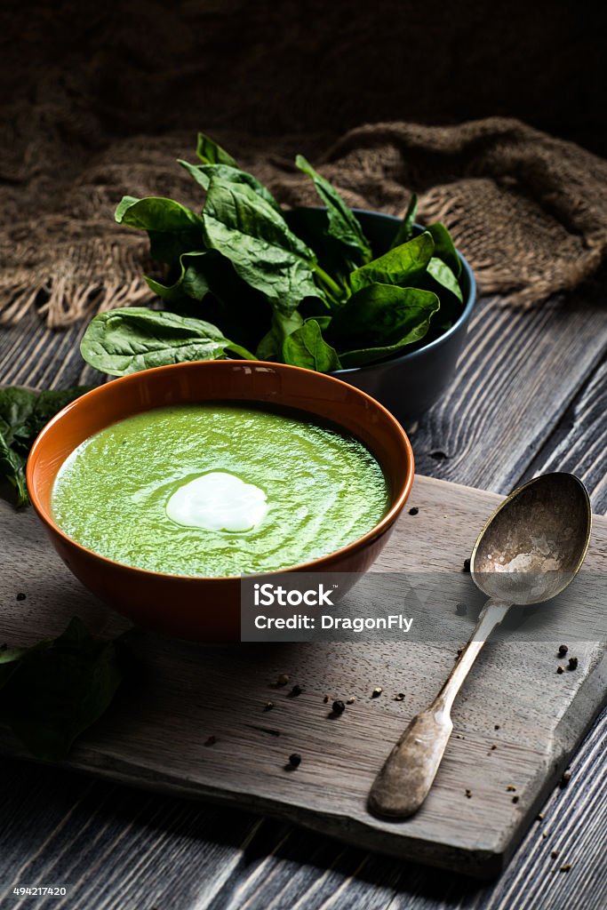 Green spinach soup Homemade spinach soup in a bowl on wooden background 2015 Stock Photo