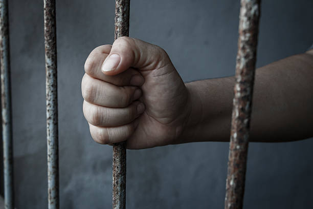 istock hands of jail holding 494219012