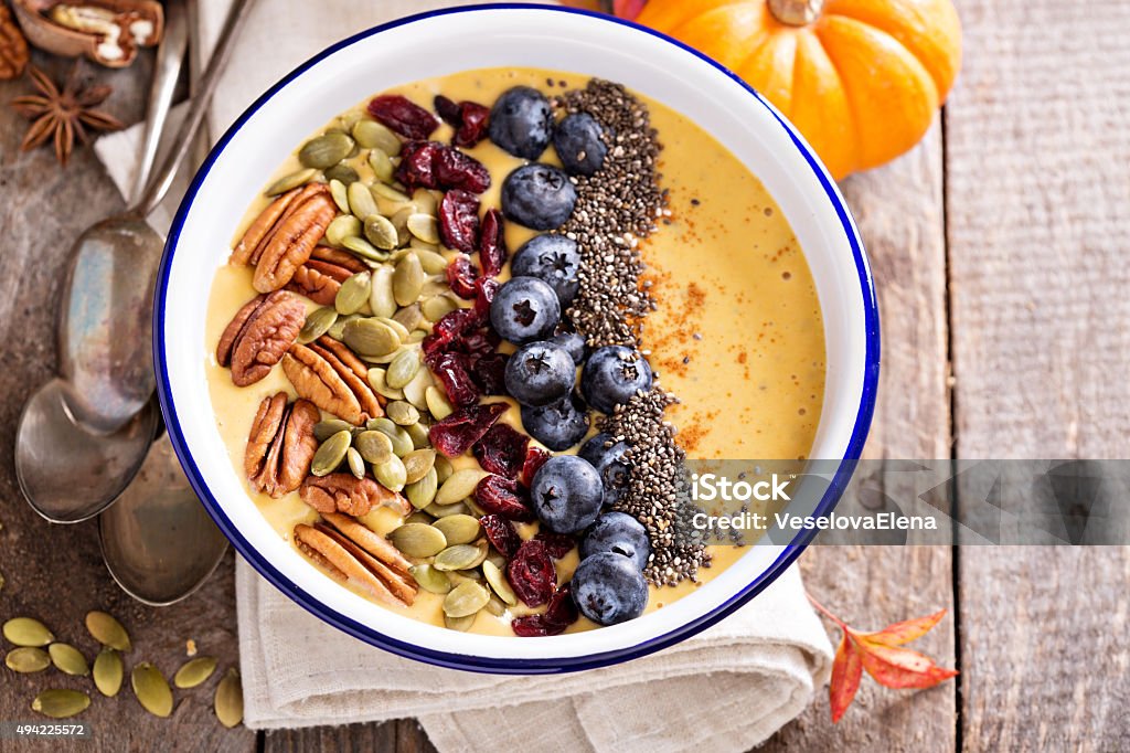 Pumpkin smoothie bowl with chia seeds, pecans, cranberries Pumpkin smoothie bowl with chia seeds, pecans, cranberries and blueberries 2015 Stock Photo