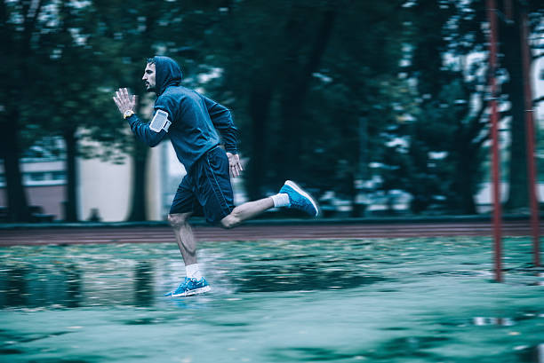 istock young motivated man running in the rain 494225798