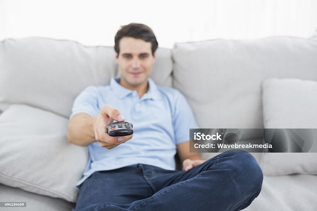 Man changing channel Man changing channel sitting on a couch 20-24 Years Stock Photo