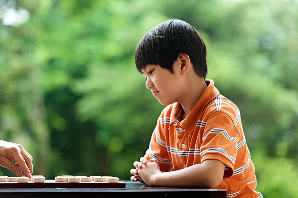 istock Asian little boy playing Xiangqi (chinese chess) 494237111