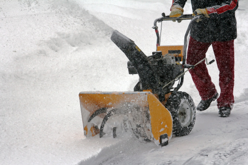 a man removes snow in winter